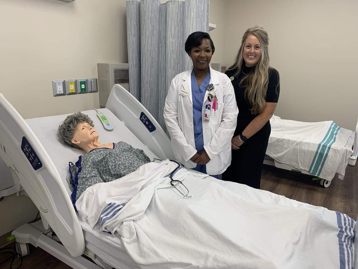 A clinical laboratory at the new Singing River Healthcare Academy teaches students before they work on actual patients. Standing at left is Carmen Potts, RN, an instructor and Jamelia Lawrence, an LPN apprentice.
