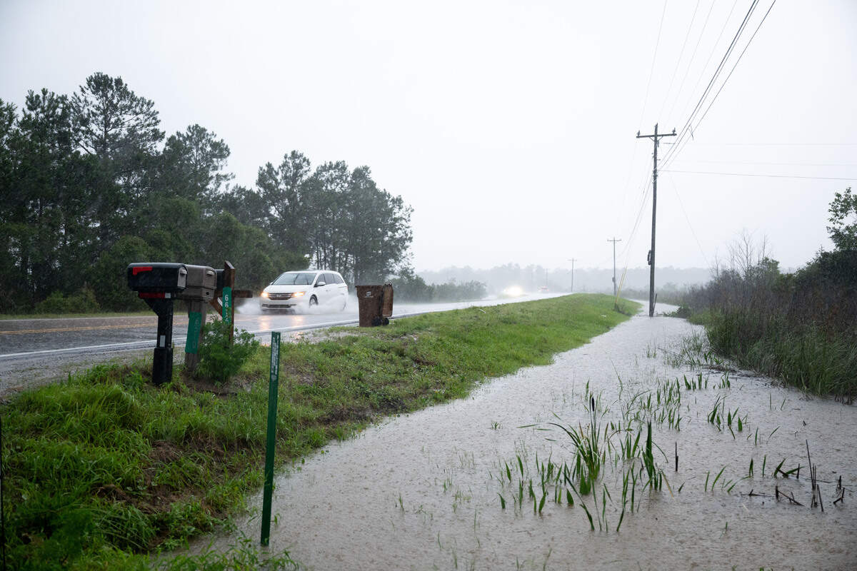 Water fills the roadside as cars drive by on Menge Avenue in Pass Christian during a rainstorm on Thursday, June 18, 2026.