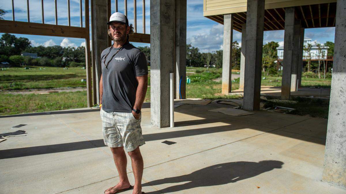 Mike Butler, a developer of The Sands housing project, stands at the base of one of his unfinished townhouses on Front Beach in Ocean Springs on Thursday, Oct. 14, 2021.