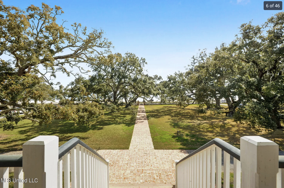 A home for sale for $4.9 million on E. Beach Boulevard in Pass Christian has a tree-lined brick walkway that leads from the home to the beach.