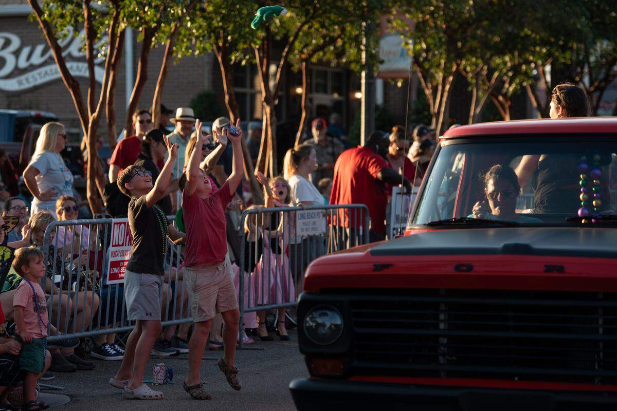 Spectators catch throws during the Long Beach Parade in Long Beach, one of the events in Cruisin’ The Coast, on Monday, Oct. 7, 2024.