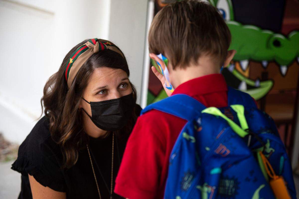 Librarian Kelsey Hardy comforts an upset child as he arrives for his first day of school.