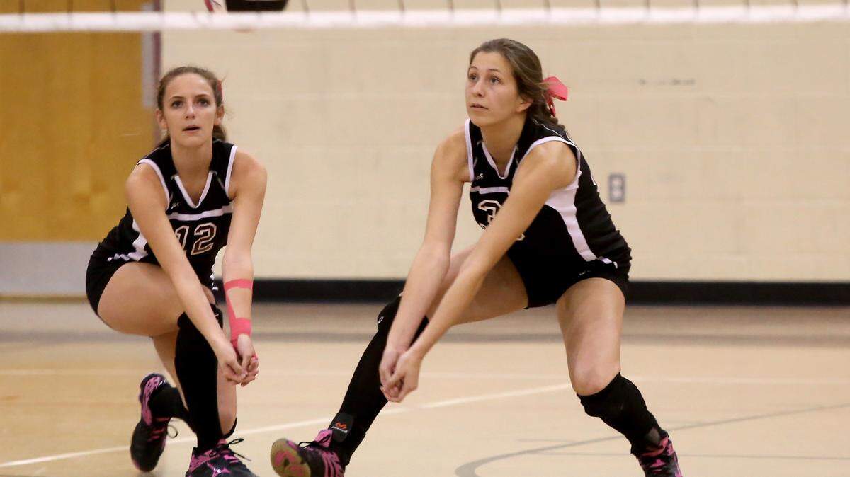 AMANDA McCOY/SUN HERALD 
 Our Lady Academy's Abby Koons, left, and Emma Funk attempt to make contact with Resurrection's serve on Sept. 22. Both OLA and RCS will participate in the second round of the Class I playoffs with a chance to face one another in the South State match on the line.