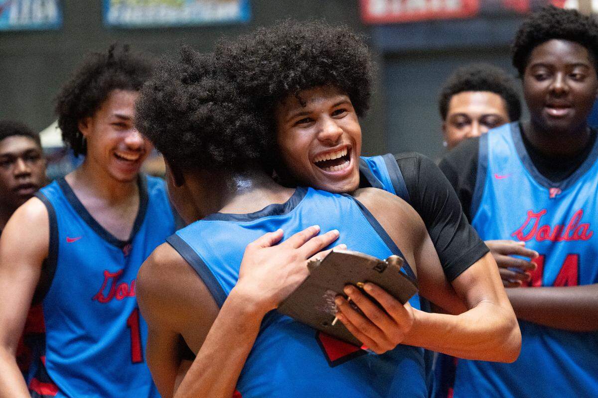 Pascagoula's Adam Griffin (12) is embraced by Pascagoula's Blake Nettles (2) after Grifin was named the game’s Most Valuable Player.