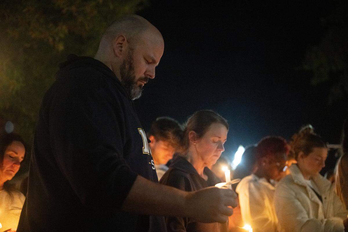 Josh Perry bows his head during the vigil Thursday in Perkinston.