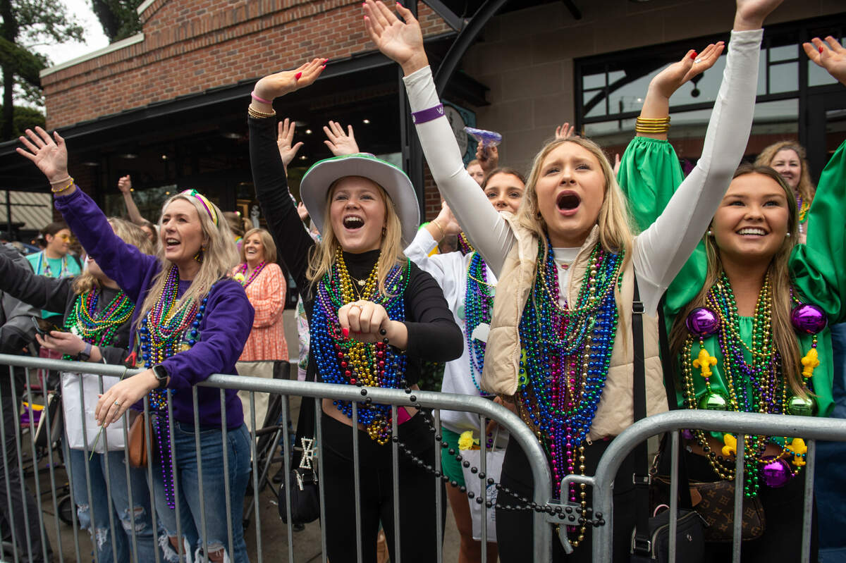 Parade attendees cheer for beads during The Ocean Springs Elks Carnival Parade in downtown Ocean Springs on Saturday, Jan. 27, 2024.