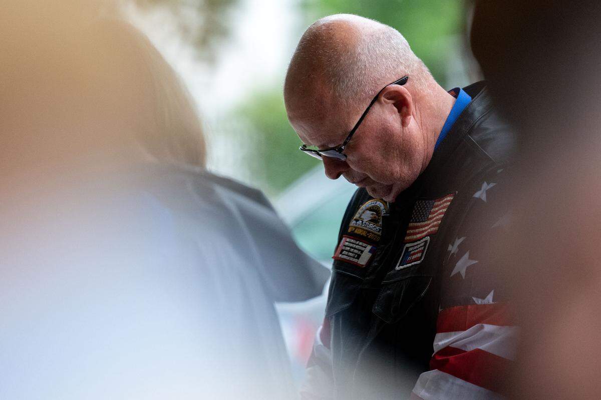 Dane Senser lowers his head during an invocation during a ceremony at Biloxi National Cemetery on Monday, May 25, 2026.