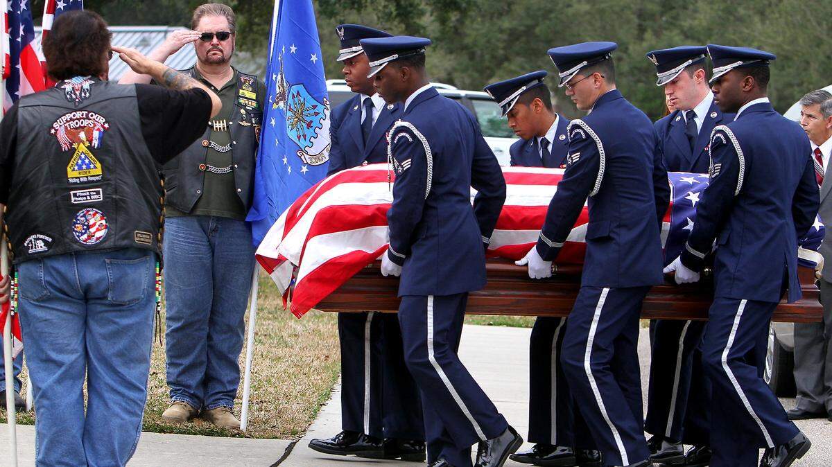 Members of the Keesler Air Force Base Honor Guard carry the coffin of Biloxi City Councilman Tom Wall as members of the Patriot Guard salute during his funeral at Biloxi National Cemetery on Friday, January 11, 2013.
