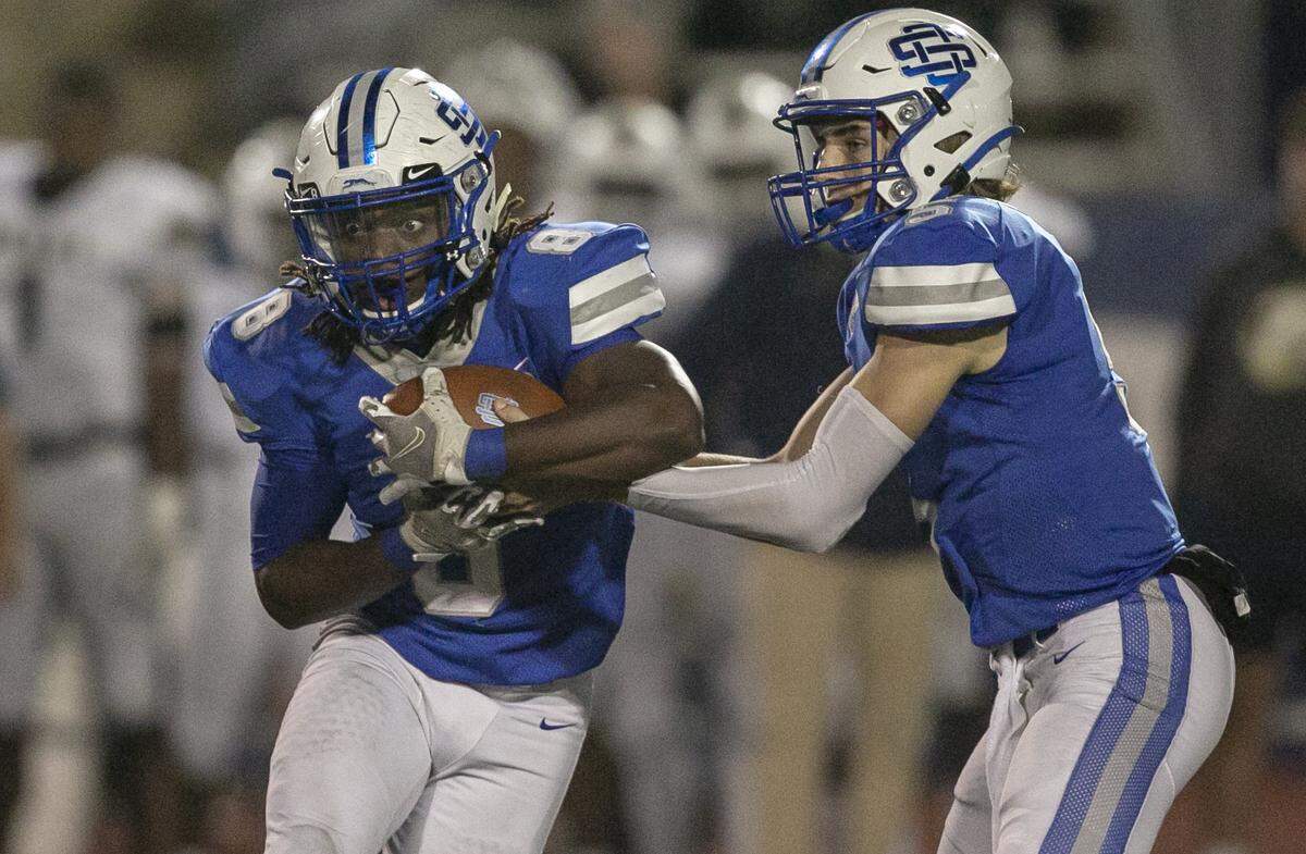 Ocean Springs quarterback Bray Hubbard passes the ball off to running back David Humphries during the game against Pearl at Greyhound Stadium in Ocean Springs on Friday, Nov. 12, 2021.