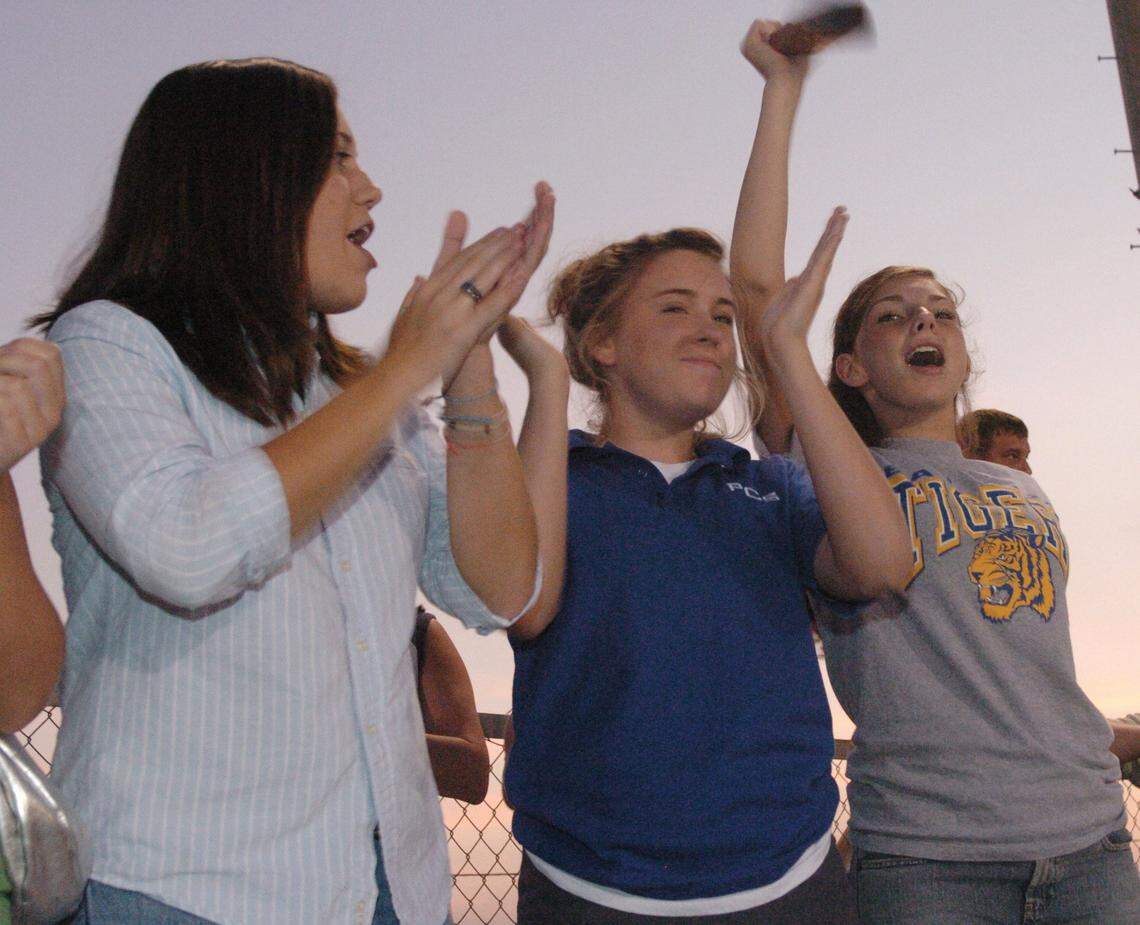 Bay High students Courtney Bissonnette, from left, Camille Keith and Katie Morris cheer on their team Sept 26, 2005. The Tigers won the game 21-19.