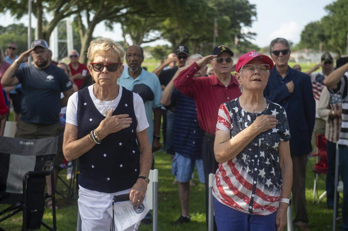 Veterans and members of the public say the pledge of allegiance during a Memorial Day ceremony at Biloxi National Cemetery in Biloxi on Monday, May 26, 2025.