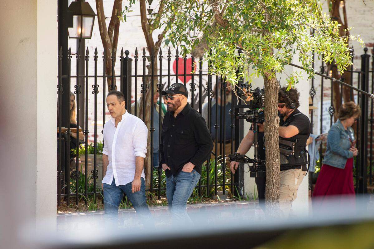 Actor John Travolta, center, and another cast member walk down Washington Avenue on the set of Cash Out 3 during filming in Ocean Springs on Tuesday, April 8, 2025.
