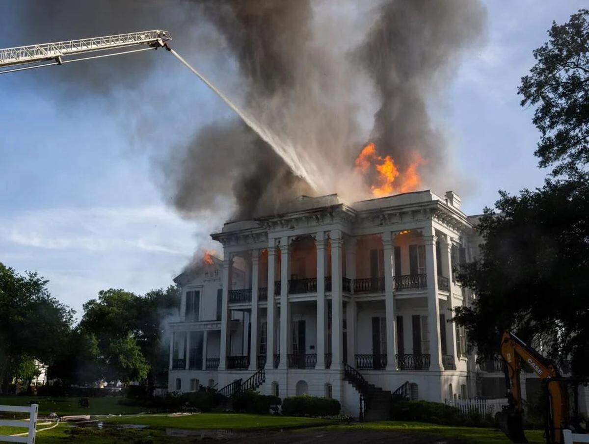 Firefighters from Baton Rouge operate Aerial 3 as flames burst from the roof of the Nottoway Plantation on Thursday, May 15, 2025, in White Castle, Louisiana.