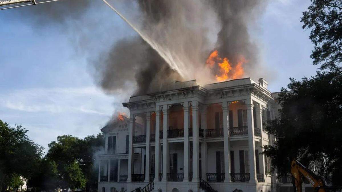 Firefighters from Baton Rouge operate Aerial 3 as flames burst from the roof of the Nottoway Plantation on Thursday, May 15, 2025, in White Castle, Louisiana.