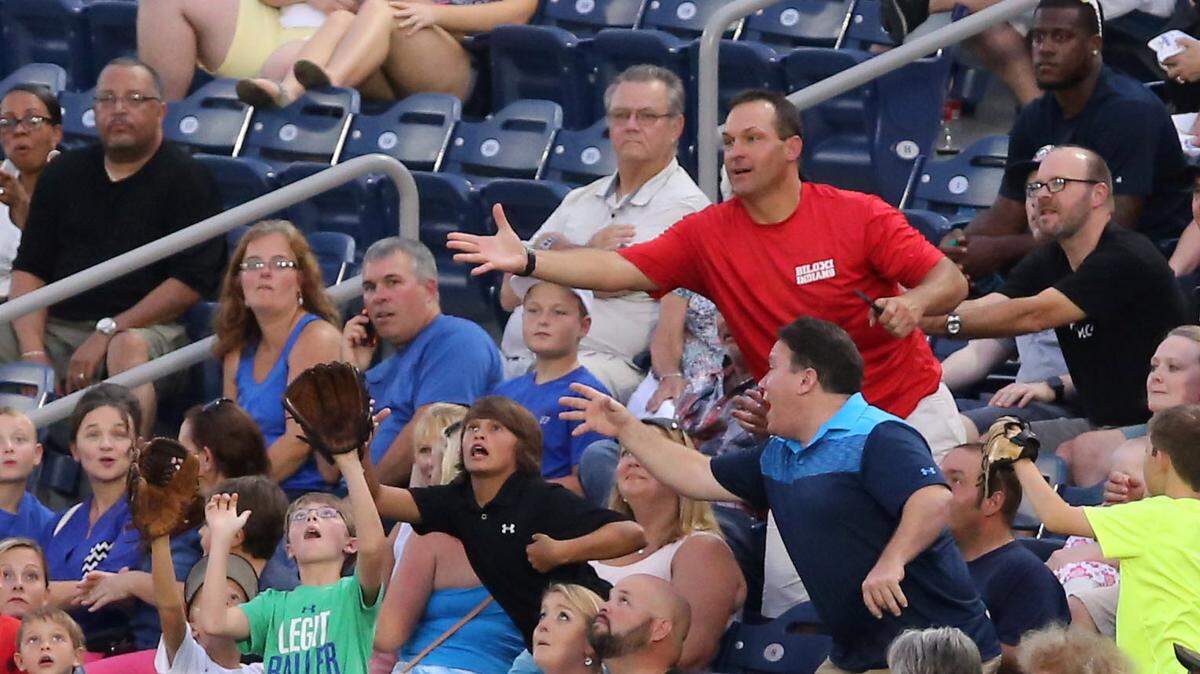 JOHN FITZHUGH/SUN HERALD 
 Fans reach for a foul ball during a Biloxi Shuckers game at MGM Park in July 2015. The park is going to expand the netting around the field to protect fans from foul balls.