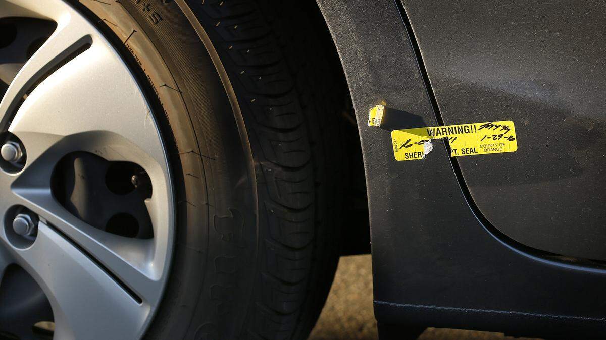 The remnants of a seal from the Orange County Sheriff's Department is still stuck on the car of Long Hoang Ma, whose vehicle was used to transport fugitvies after a recent Orange County, Calif., jailbreak. (Rick Loomis/Los Angeles Times/TNS)