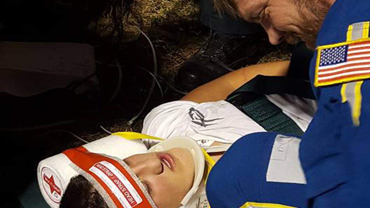PHOTO COURTESY SHONDA MULLIKIN 
 
 A responder with Life Flight talks to Austin Shaw just before he was taken from a football field in Hurley to Memorial Hospital at Gulfport. Shaw suffered a neck spasm, but was air-lifted to the hospital as a precaution.