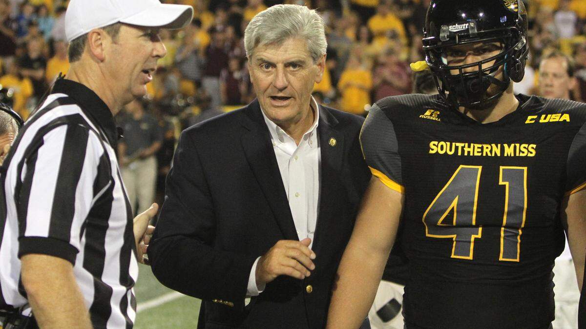 TIM ISBELL/SUN HERALD 
 USM long snapper Lance Schuffert stands with Gov. Phil Bryant for the coin toss before their game against Mississippi State on Saturday, Sept. 5, 2015.