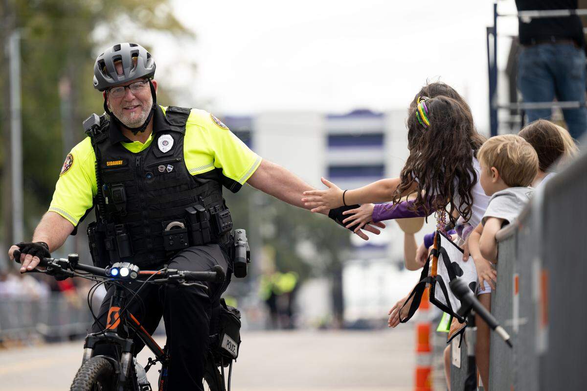 A Biloxi Police Officer high fives children as he rides down Lameuse Street during the Gulf Coast Carnival Association’s Fat Tuesday parade in Biloxi on Tuesday, Feb. 17, 2026.