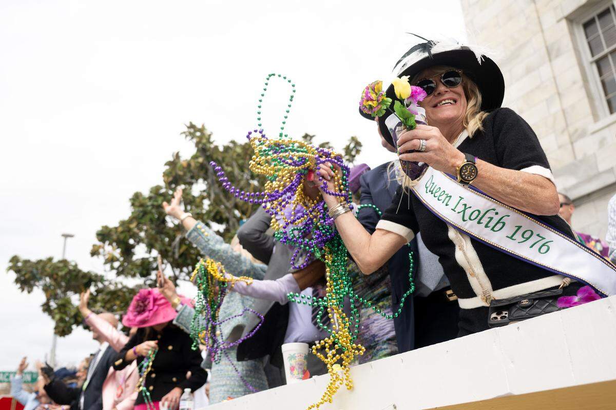 1976 Queen Ixolib Eileen Mahoney catches Mardi Gras beads.