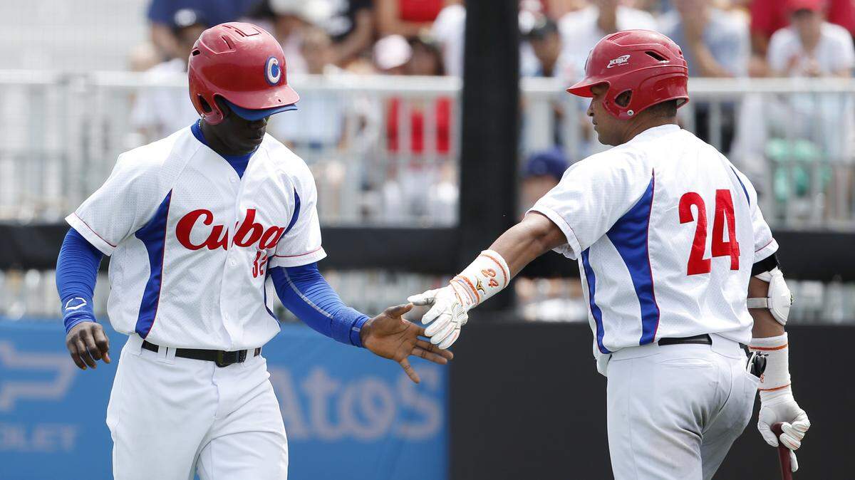 JULIO CORTEZ/ASSOCIATED PRESS 
 Cuba's Jose Garcia, left, is congratulated by teammate Frederich Cepeda after scoring a run on a groundout by Alfredo Despaigne during the first inning of the bronze medal baseball game at the Pan Am Games, Sunday, July 19, 2015, in Ajax, Ontario, Canada. Coast casino executive Bobby Carter is working to bring the team to MGM Park in Biloxi for an exhibition against an American team.