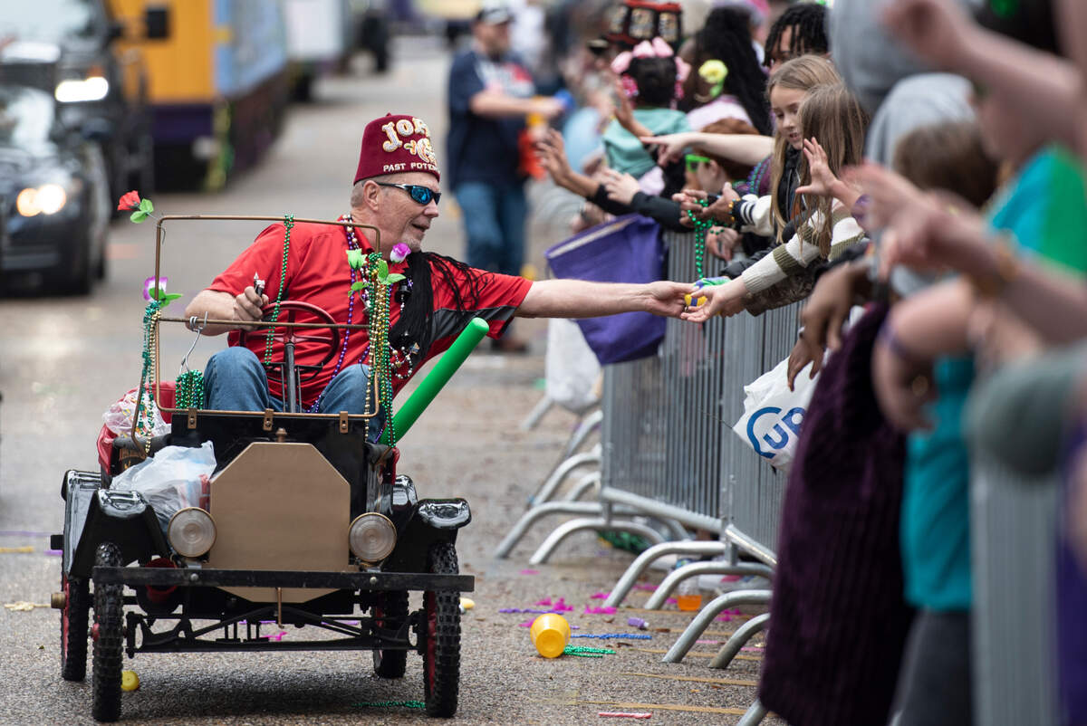Members of a Shriner’s club pass out throws during the Ocean Springs Elks Carnival Parade in downtown Ocean Springs on Saturday, Jan. 27, 2024.