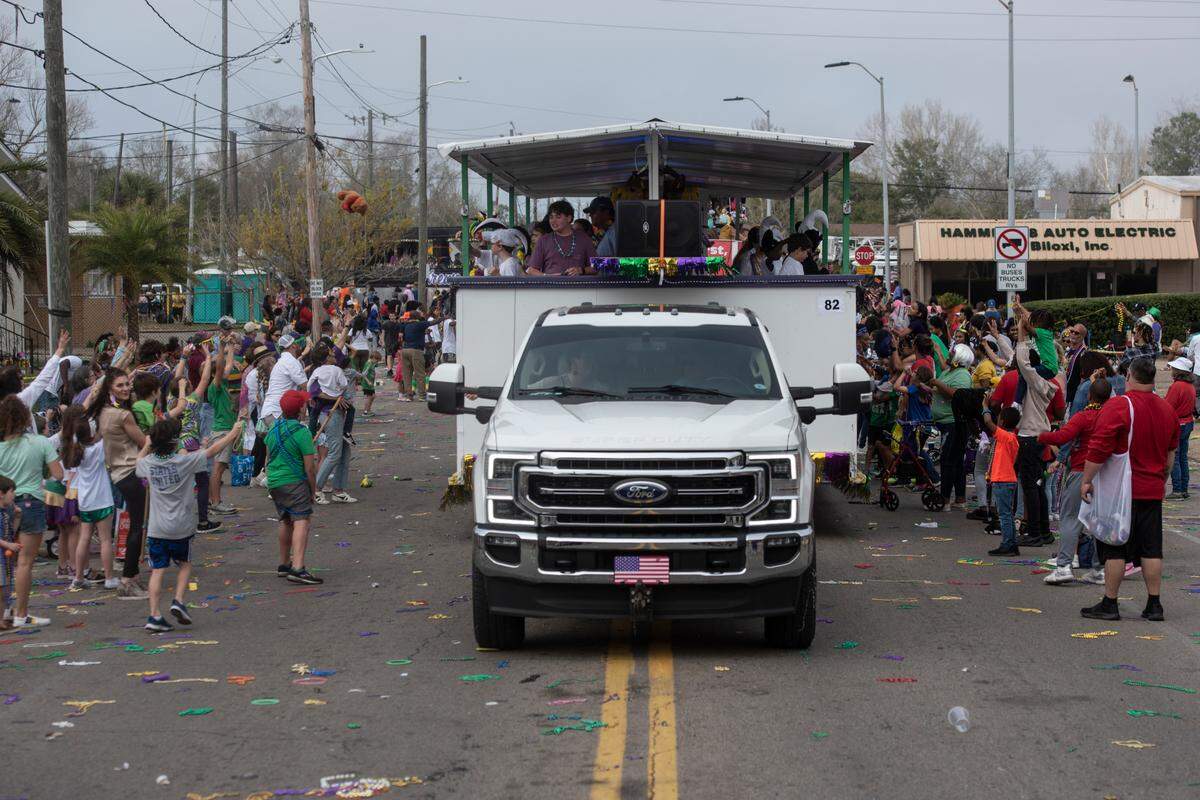 Float riders toss beads and stuffed animals to the crowd during the Gulf Coast Carnival Association Mardi Gras parade in Biloxi on Tuesday, Feb. 21, 2023.
