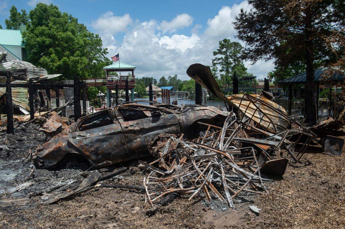 A burned out car sits in the remnants of a house on Highway 603 in Kiln on Tuesday, May 31, 2022. A fire consumed the house and the house next door on Saturday night, killing two.