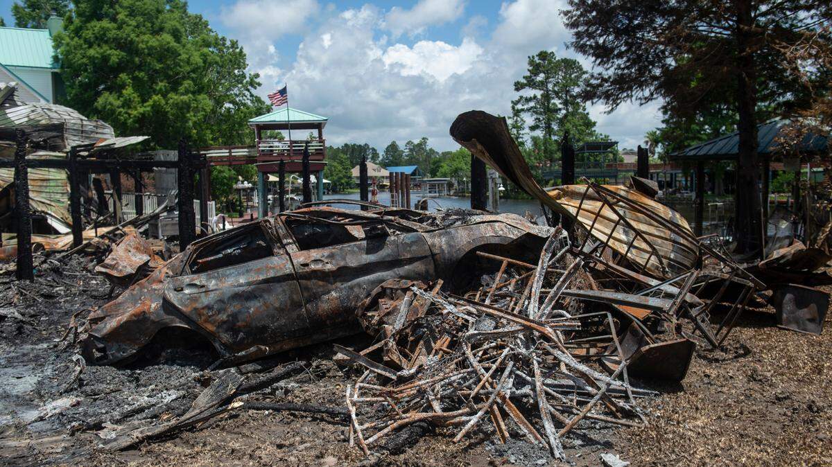 A burned out car sits in the remnants of a house on Highway 603 in Kiln on Tuesday, May 31, 2022. A fire consumed the house and the house next door on Saturday night, killing two.