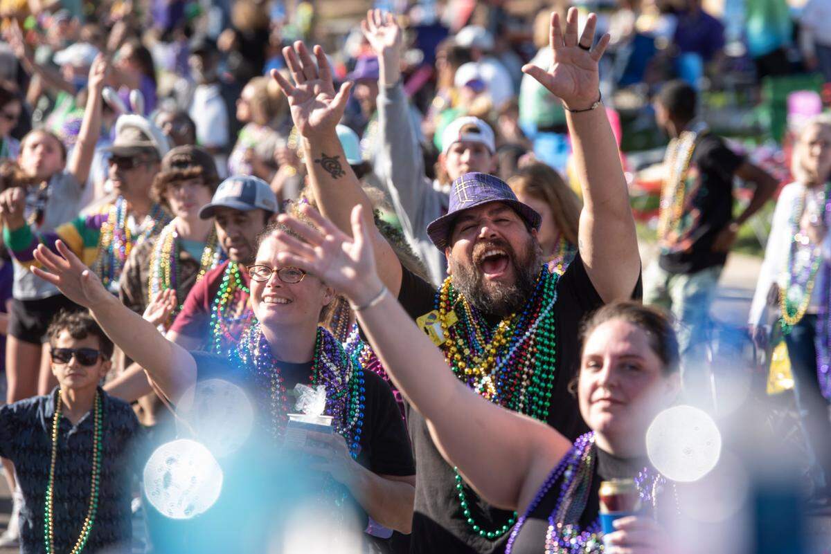 Paradegoers cheer for beads during the Gulf Coast Carnival Association Mardi Gras parade in Biloxi on Tuesday, Feb. 21, 2023.