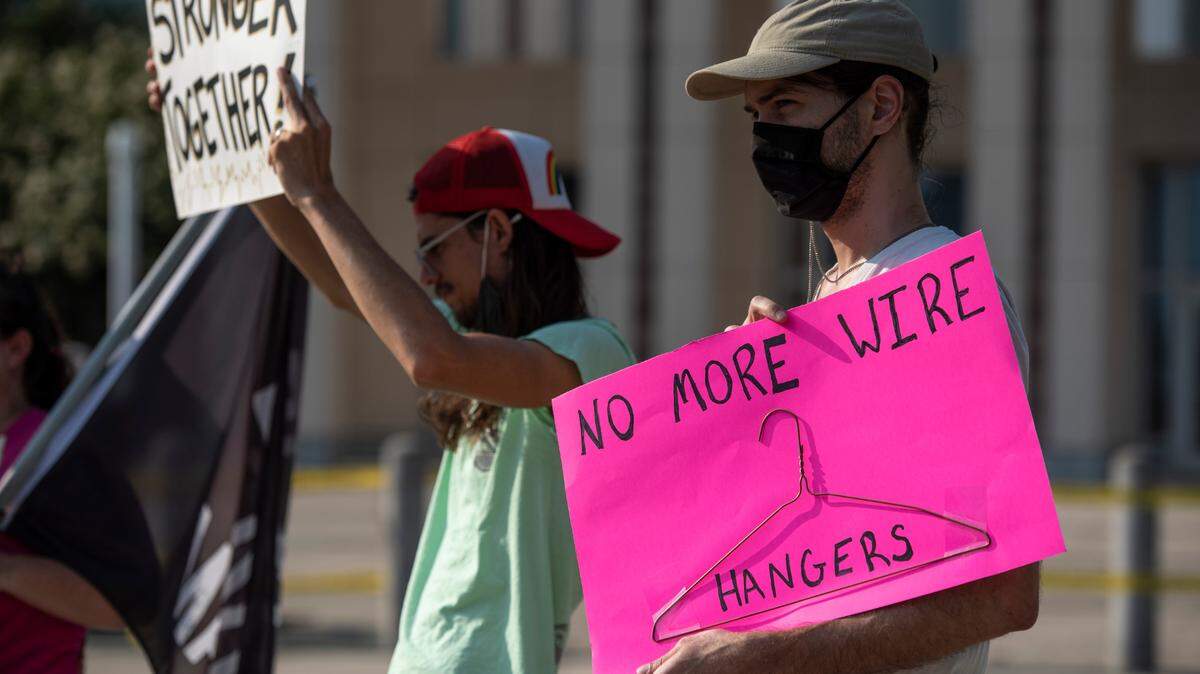 Dustin and CJ Nickell-Templin hold signs during a protest against the Supreme Court Dobbs vs Jackson Women’s Health decision that reversed Roe vs Wade outside the Dan M. Russell Jr. Courthouse in Gulfport..