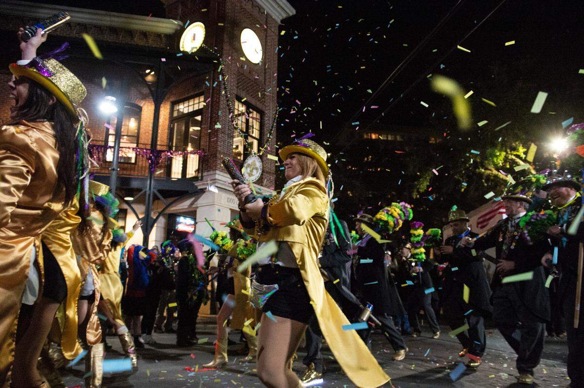 The Ole Biloxi Marching Club sets off confetti poppers during the Ocean Springs Carnival Association Night Parade in Ocean Springs on Friday, Feb. 25, 2022.