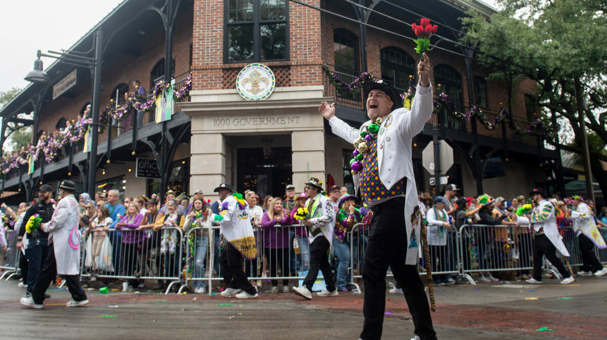 A member of a marching club cheers as he turns onto Government Street during The Ocean Springs Elks Carnival Parade in downtown Ocean Springs on Saturday, Jan. 27, 2024.
