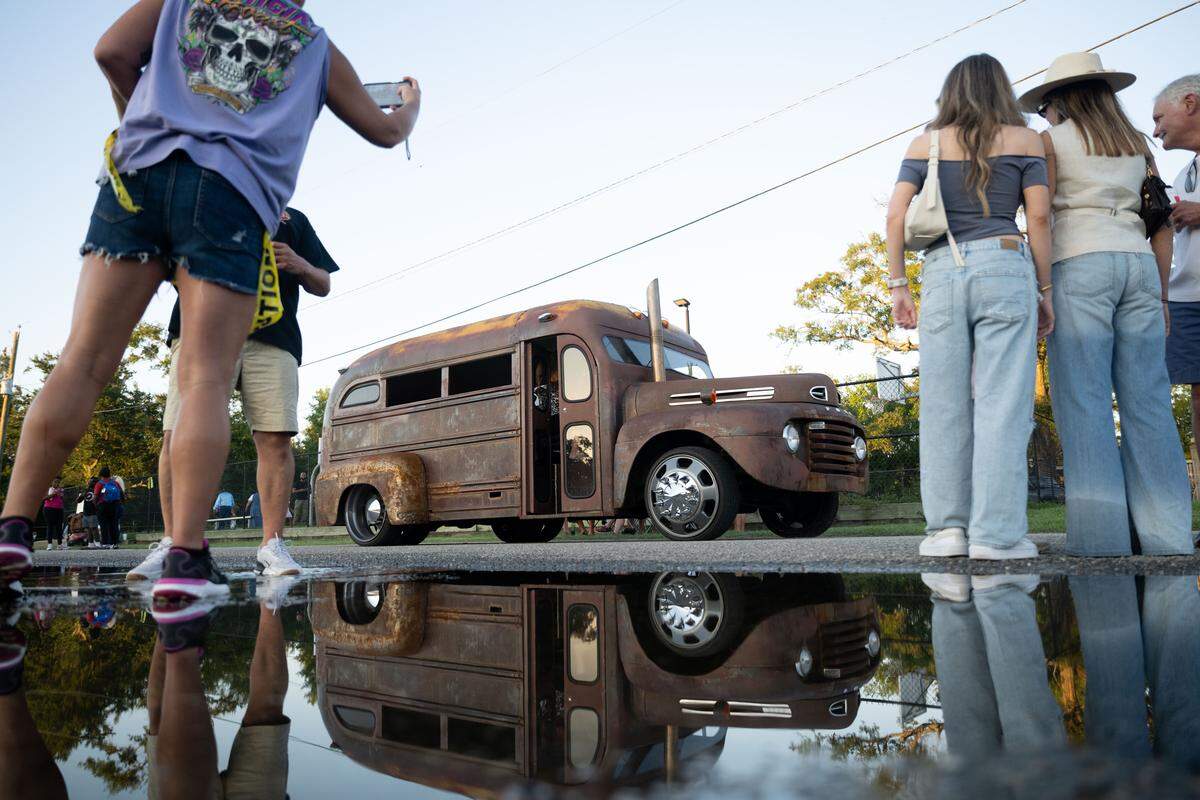People watch as a vintage bus leaves Burn ‘Em Up In The Pass on Thursday, Oct. 9, 2025.