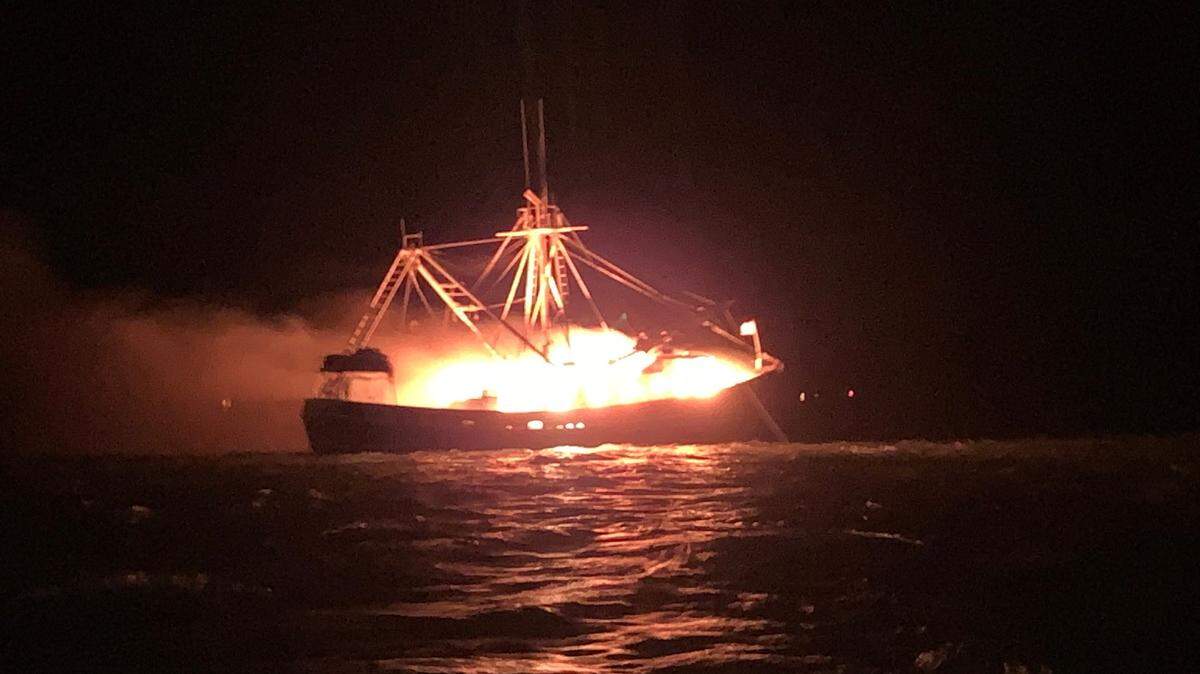 The U.S. Coast Guard rescued four people Monday from a burning vessel near Fort Morgan, Alabama.