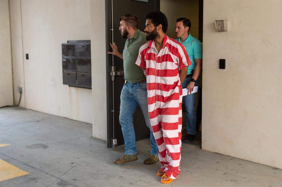 Denilson Marcus Ellison, 27, of Gulfport, is escorted out of the Gulfport Police Department to a waiting vehicle after interviewing with detectives on Friday, April 26, 2024. Ellison is charged with capital murder in the death of his four month old child.