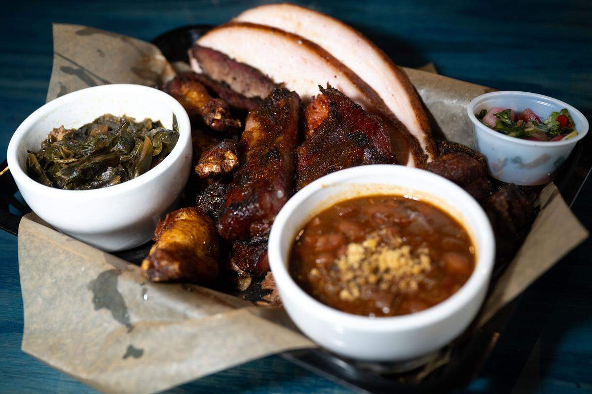 The carnivore is a sampler of smoked turkey, ribs, smoked wings, pulled pork and pork cracklings served alongside pickled collards at Boonies on the Bayou on Friday, Dec. 5, 2025.