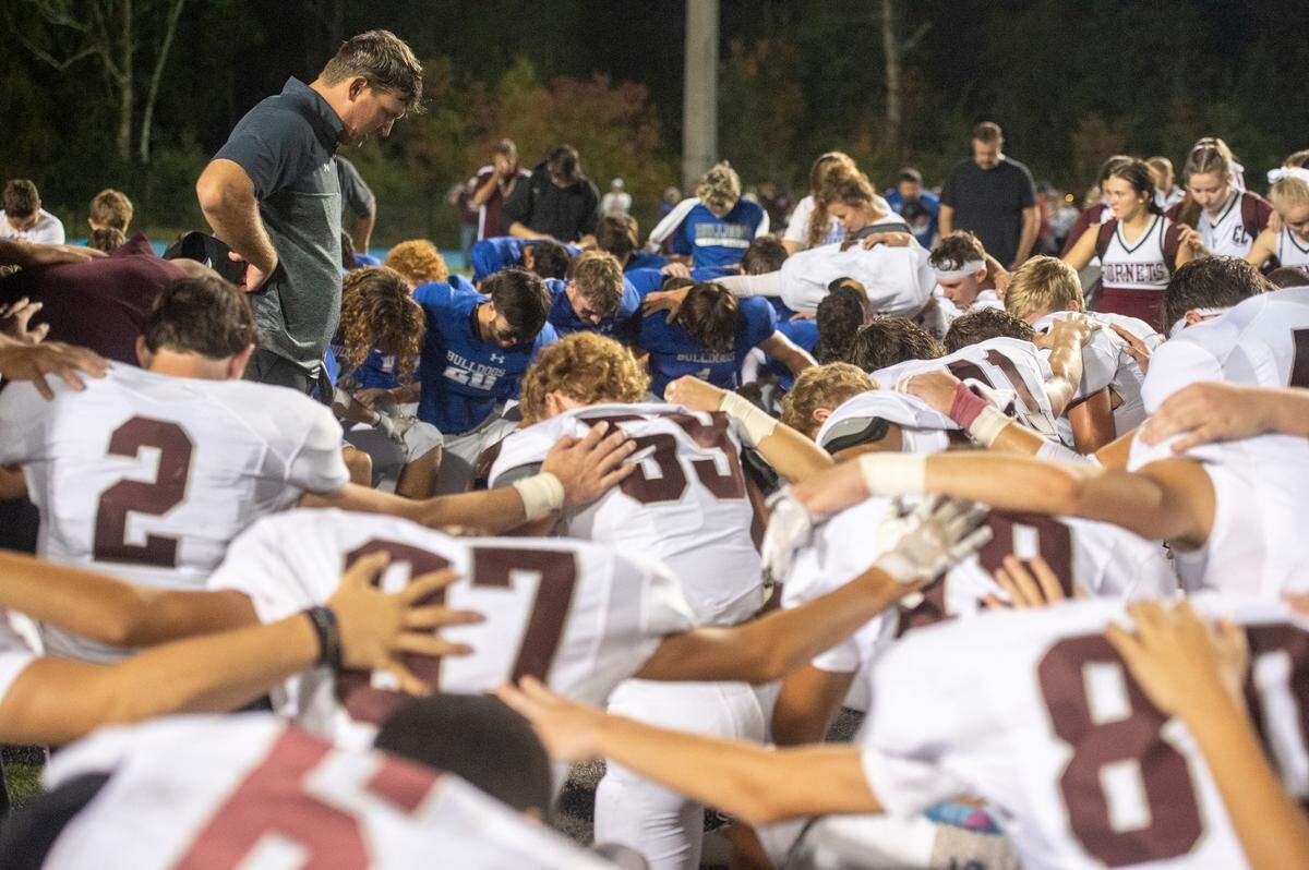A Vancleave coach leads a prayer after a game between Vancleave and East Central at Vancleave Football Stadium in Vancleave on Thursday, Nov. 3, 2022. East Central won 28-21.