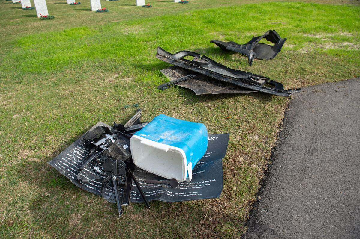 Debris from a pickup truck sit at Biloxi National Cemetery in Biloxi on Monday, Dec. 4, 2023, after the pickup truck ran over several sections of the cemetery on Sunday.