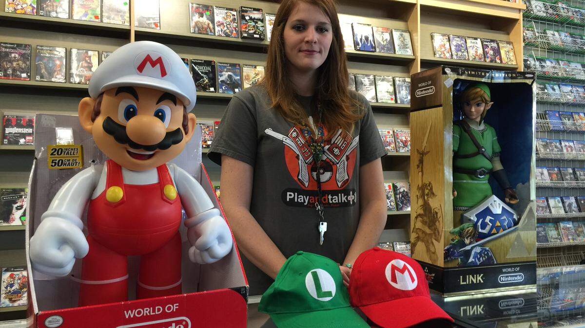 JUSTIN MITCHELL/SUN HERALDPlay and Talk Gulfport employee Courtney Cuevas shows off the prizes the top finishers will win in a video-game tournament Dec. 18 benefiting Toys for Toys.