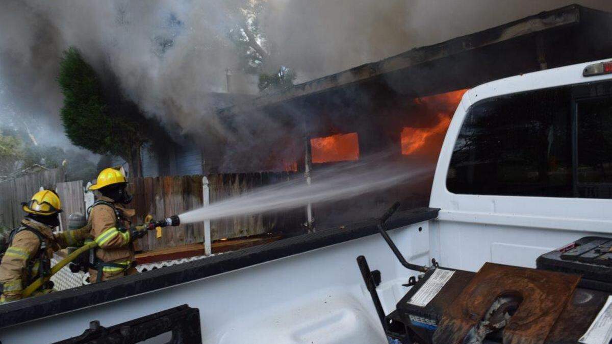 TIM REGAN/GULFPORT FIRE DEPARTMENTFirefighters battle flames as another crew inside searches for a woman trapped inside the burning home on Gulf Avenue in Gulfport Thursday afternoon.