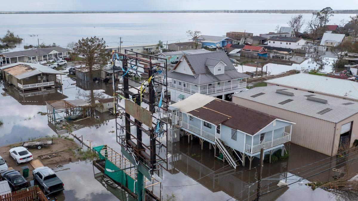 Flood waters surround storm damaged homes on Aug. 31, 2021, in Lafourche Parish, La., as residents try to recover from the effects of Hurricane Ida. Louisiana and nine other states filed a lawsuit against the federal government Thursday to block sharp impending national flood insurance rate increases slated to be phased in over the coming years, saying the steeper costs could cost some people their homes. (AP Photo/Steve Helber)