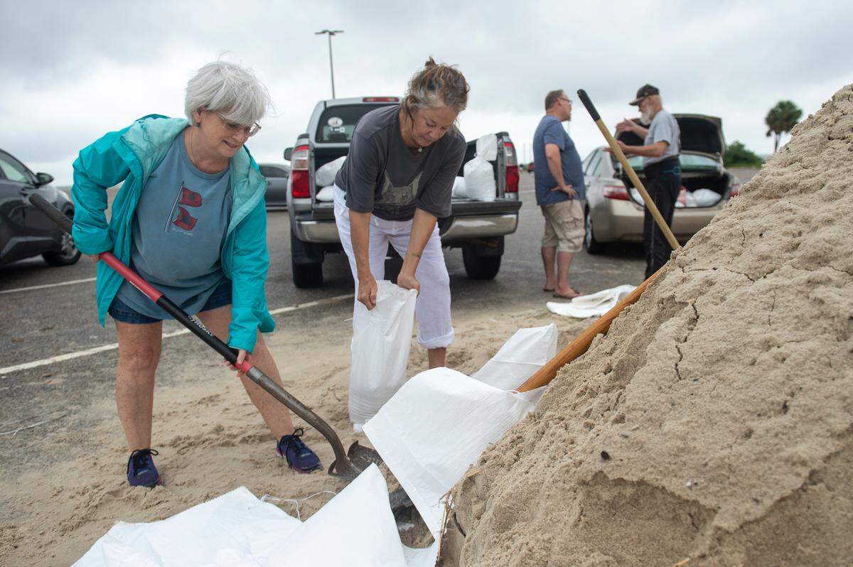 Friends Beth Hatch and Jane Glenn, of Gulfport, fill sandbags at the end of Courthouse Road in Gulfport Tuesday, Both lost their homes during Hurricane Katrina. The City of Gulfport has issued a curfew for Wednesday evening into Thursday to protect the public.