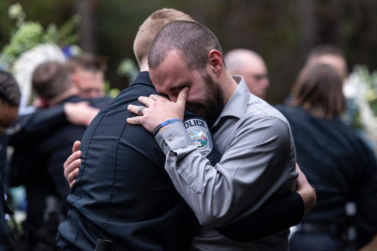 Bay St. Louis police officers react as Capt. Rachel Jewell calls in the last radio call at the gravesite of Bay St. Louis police officers Sgt. Steven Robin and Branden Estorffe at Gardens of Memory cemetery in Bay St. Louis on Wednesday, Dec. 21, 2022. Robin and Estorffe were killed responding to a call at a Motel 6 on Dec. 14.