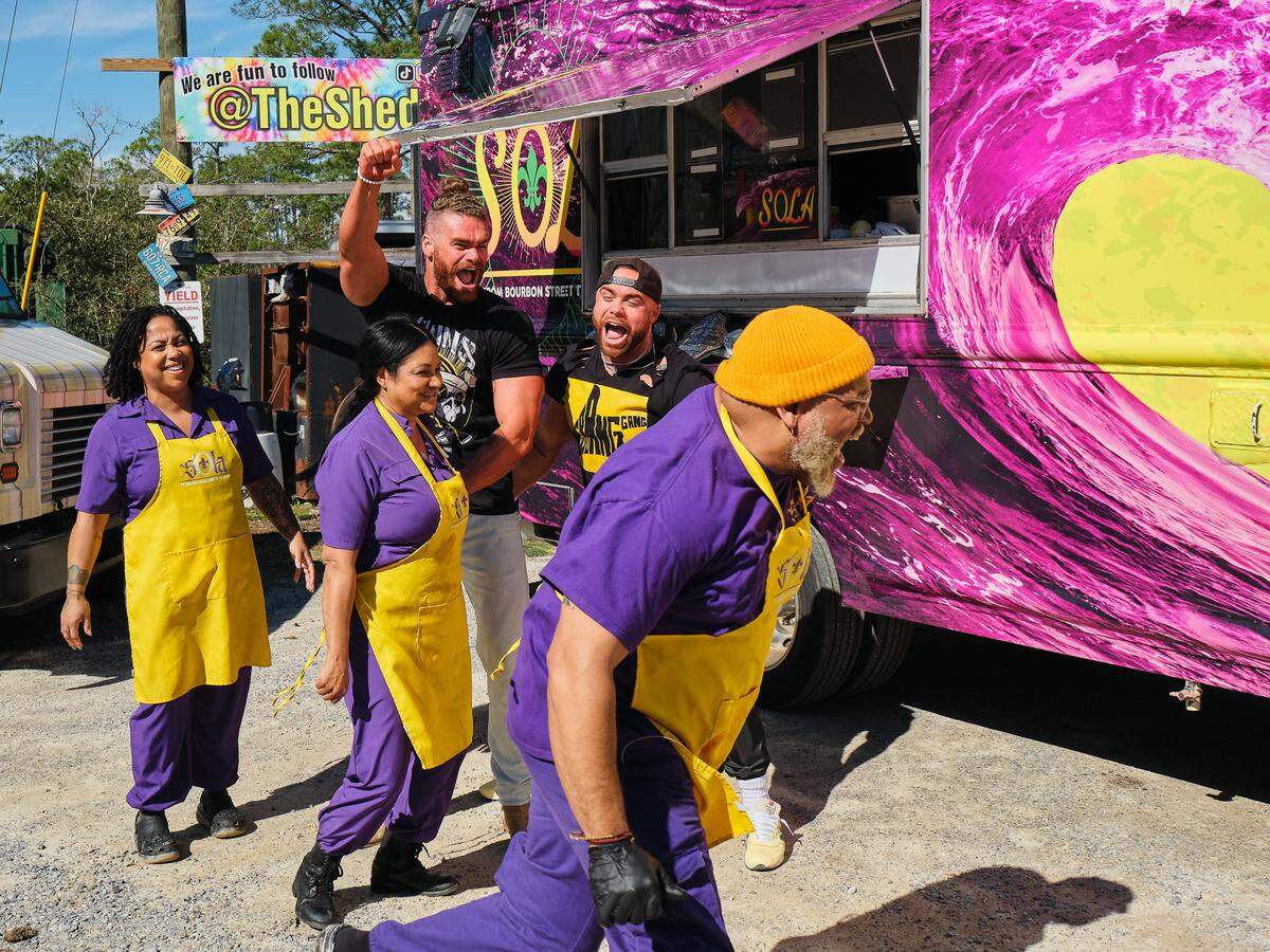 The Sola Po’boys team is cheered on by All Elite Wrestling tag team The Gunns during the Great Food Truck Race competition at The Shed in Ocean Springs.
