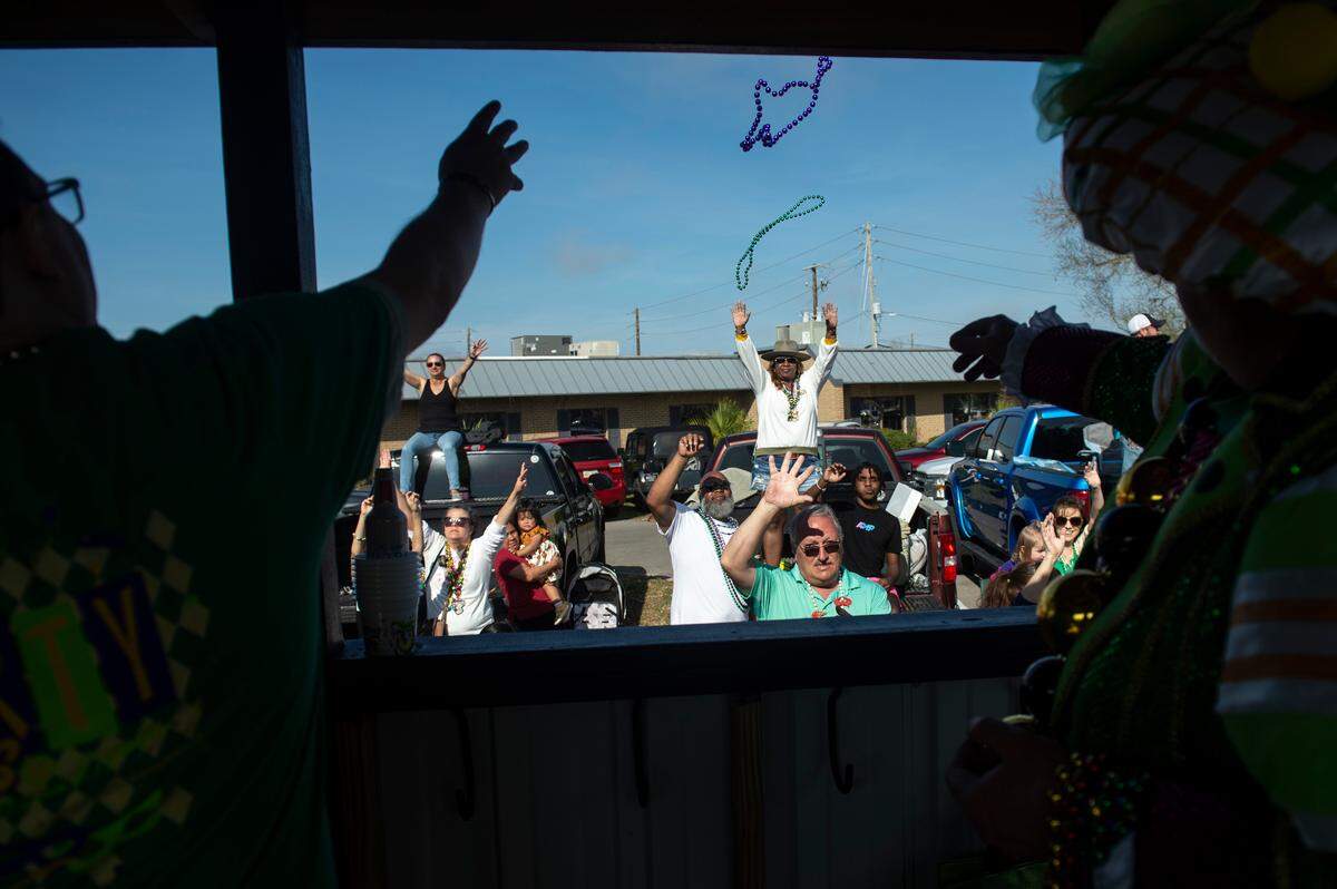 Float riders toss beads to the crowd during the Gulf Coast Carnival Association Mardi Gras parade in Biloxi on Tuesday, Feb. 21, 2023.