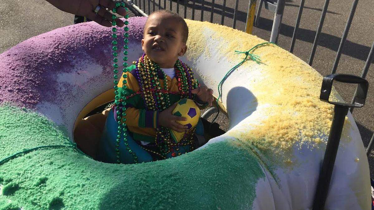 JEFF CLARK/SUN HERALDCooper Danzey enjoys his first Mardi Gras parade from his very own mobile king Cake Saturday.