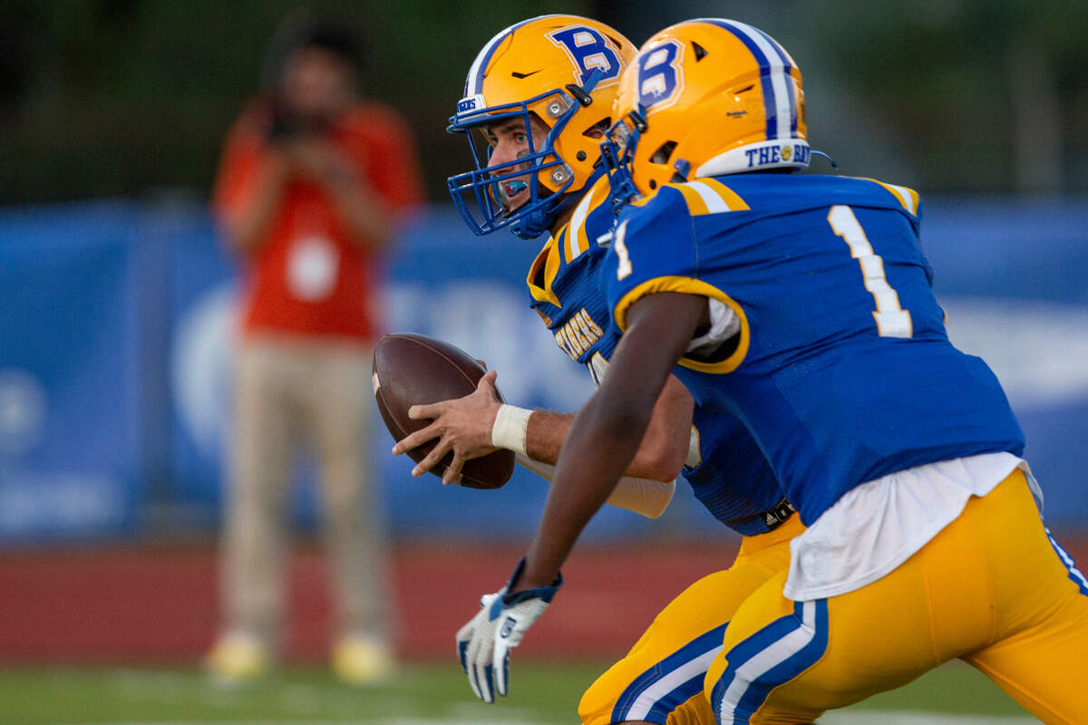 Bay High’s Xander Ladner passes the ball off to Jaylen Antoine during a game between Bay High and Long Beach at Tiger Stadium in Bay St. Louis on Friday, Sept. 13, 2024.