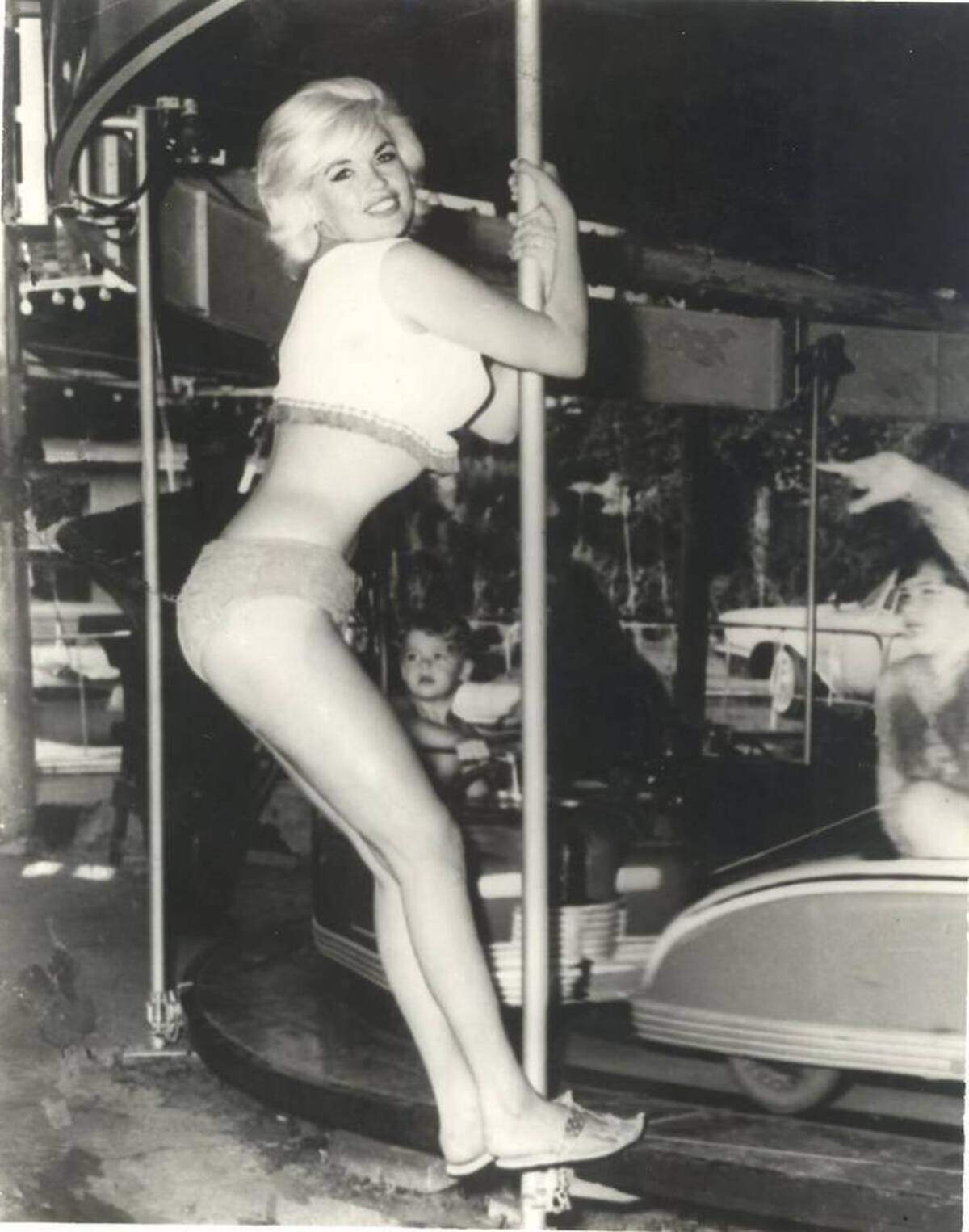 Actress Jayne Mansfield poses on a tiny car merry-go-round in Biloxi while her children enjoy a ride beside the beach. Pascagoula photographer Wallace Reeves, who shot the picture, said it was the last posed photo taken before she was killed in the early hours June 29, 1967, in a traffic accident.