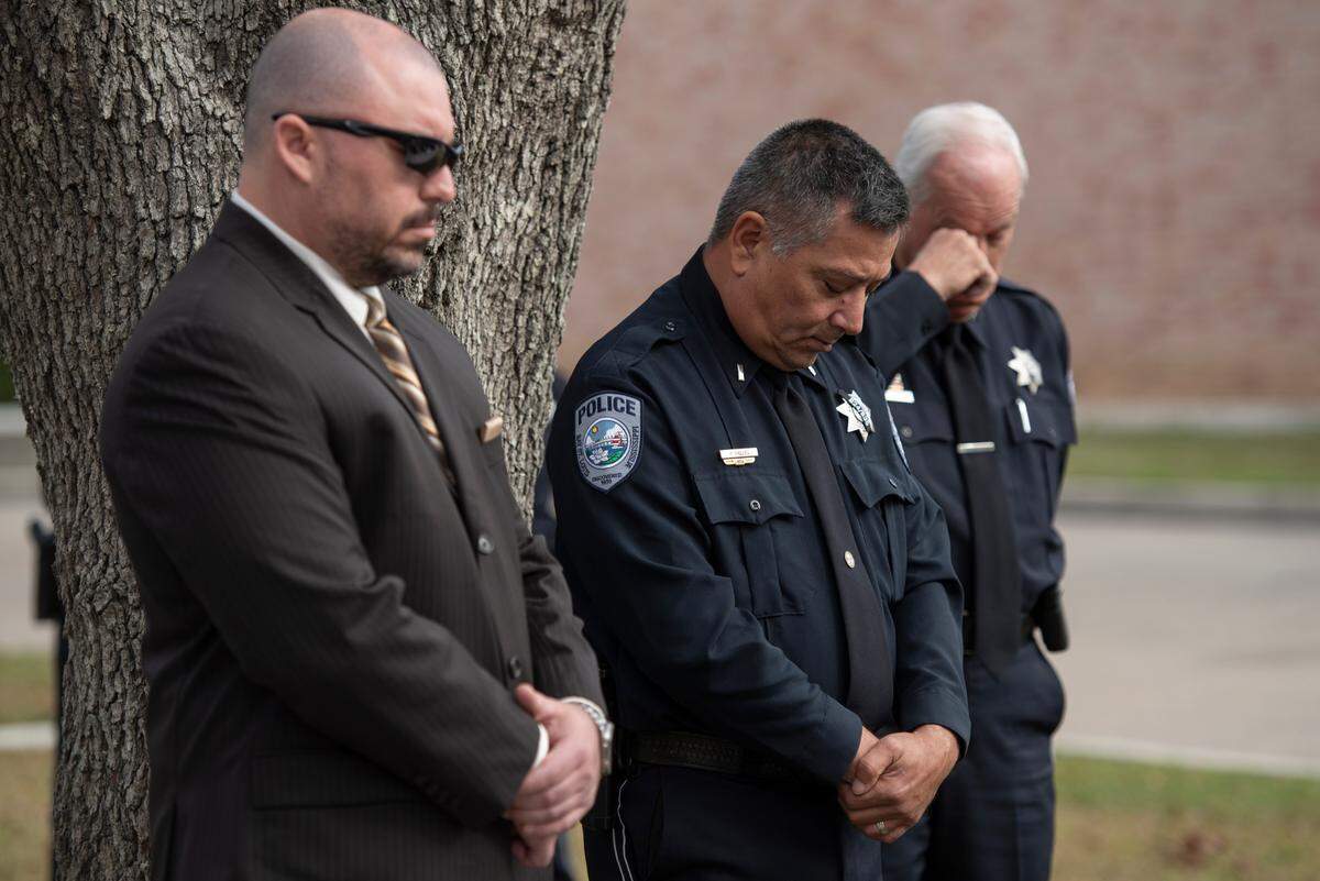 Members of the Bay St. Louis Police Department bow their heads as a prayer is said during a ceremony dedicating commemorative stars in honor of Sergeant Steven Robin and Officer Branden Estorffe outside the new Bay St. Louis Police Department in Bay St. Louis on Dec. 14, 2023. 